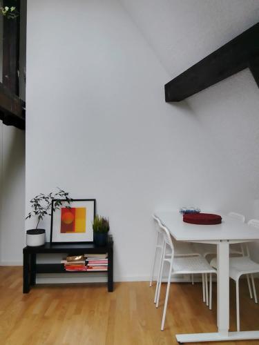 a white dining room with a table and chairs at Basel Rühige Zimmer mit grösse Doppelbett in Binningen