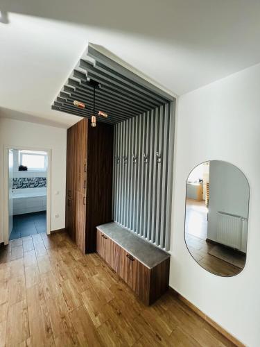 a bathroom with a mirror and a bench in a room at Apartment Richy Brasov in Braşov