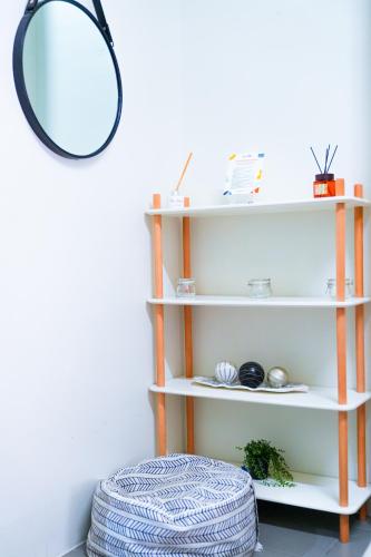 a white shelf with a mirror and a stool at The City Flats Amorsolo in Manila