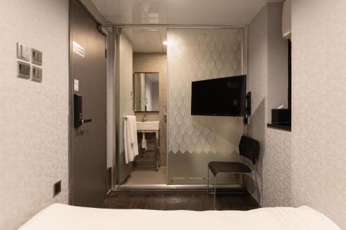 a hotel room with a bed and a sliding glass door at Atlas Hostel & Backpackers in Hong Kong