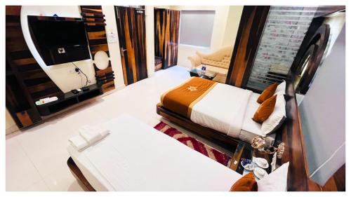 a bedroom with a bed and a couch and a television at The Five Inn in Muzaffarpur