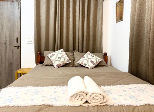 a bed with two towels and pillows on it at Serendipity Goa - Apartments and Cafe in Arambol