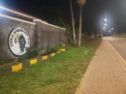 a sign on the side of a wall at night at Gorilla African Guest House in Entebbe