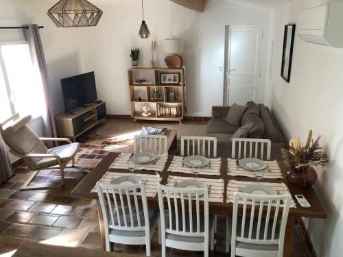 a living room with a table and chairs at Gite 5 pers en Provence avec grand jardin & piscine partagés - 5 people holiday home with shared swimming pool & garden in Provence in Cornillon-Confoux