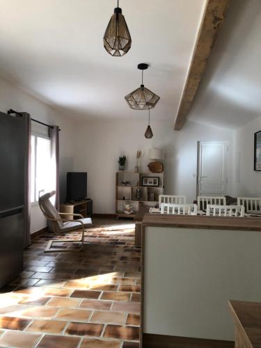 a living room with a counter and a table at Gite 5 pers en Provence avec grand jardin & piscine partagés - 5 people holiday home with shared swimming pool & garden in Provence in Cornillon-Confoux