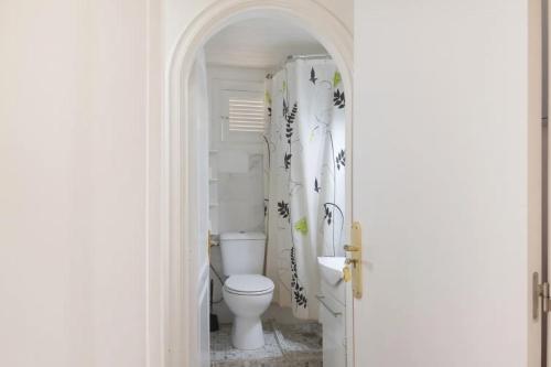 a white bathroom with a toilet in a room at Apartamento con jardín y pequeña piscina privada para refrescarse in Maspalomas