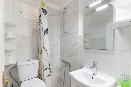 a white bathroom with a toilet and a sink at Apartamento con jardín y pequeña piscina privada para refrescarse in Maspalomas