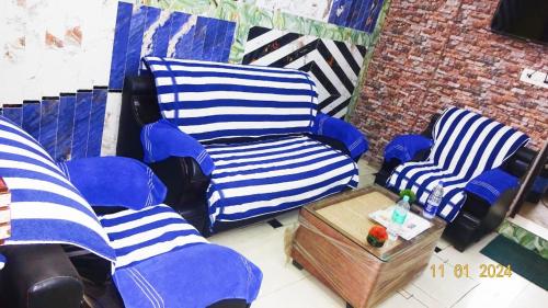 a room with blue and white chairs and a table at A1 Guest House in Tālcher