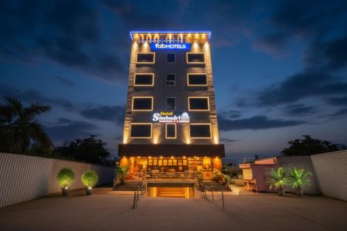 a hotel building with a sign on it at night at FabHotel Simhadri Grand-Nr Khammam Railway Station in Khammam