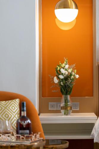 a vase of flowers on a table with a bottle of wine at La Seine Hotel in Vientiane