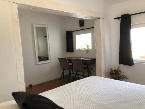 a bedroom with a bed and a table and a window at Gite 5 pers en Provence avec grand jardin & piscine partagés - 5 people holiday home with shared swimming pool & garden in Provence in Cornillon-Confoux