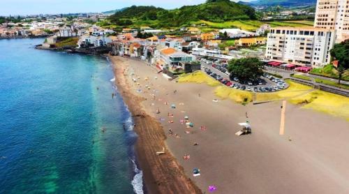 an aerial view of a beach with people in the water at 3 balconies with sea view - restaurants below - personalized support - Ponta Delgada -DOMOSTAY AL in Ponta Delgada