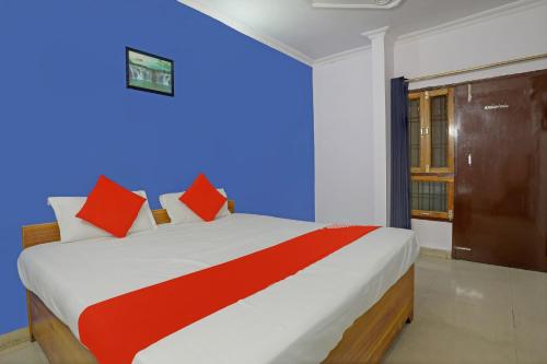 a bedroom with a large bed with red pillows at Hotel O APM Palace in Hasanganj