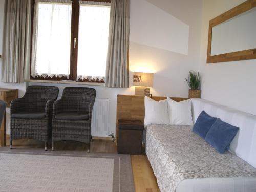 a living room with a bed and two chairs at Abis Ferienwohnung Salzkammergut in Strobl