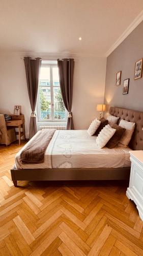 a bedroom with a large bed and a window at La Villa Alma Colmar in Colmar