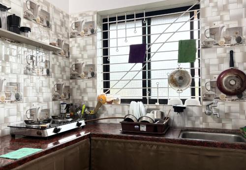 a kitchen with a sink and a stove and a window at Serendipity Goa - Apartments and Cafe in Arambol
