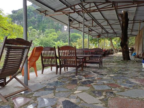 a group of wooden benches sitting under a roof at Trang An Pristine View homestay in Ninh Binh