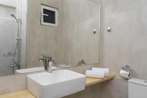 a bathroom with a white sink and a mirror at Calamos Beach Family Club in Kalamos