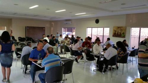 a group of people sitting at tables in a room at Hotel Nacional in Jataí