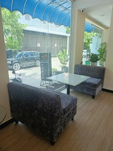 a room with two couches and a table and a window at Sai & Su Hotel in Phnom Penh