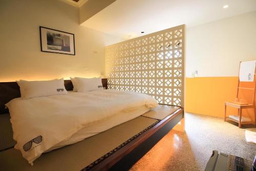 a bedroom with a bed with a latticed wall at Yellow House in Hengchun