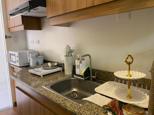 een aanrecht met een spoelbak en een magnetron bij La Mari 1 bedroom at Prisma Residences in Manilla