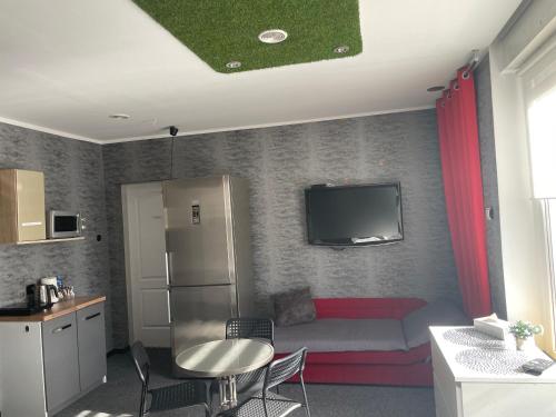 a room with a bed and a refrigerator and a kitchen at Apartamenty Konopnicka in Bydgoszcz