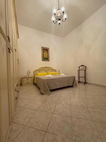 a bedroom with a bed and a chandelier at Casa Vacanze Janas in Assemini