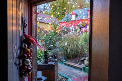 a window with a christmas tree in a garden at Au2 Maison d'Hôtes - Guest House Au2 in Muidorge