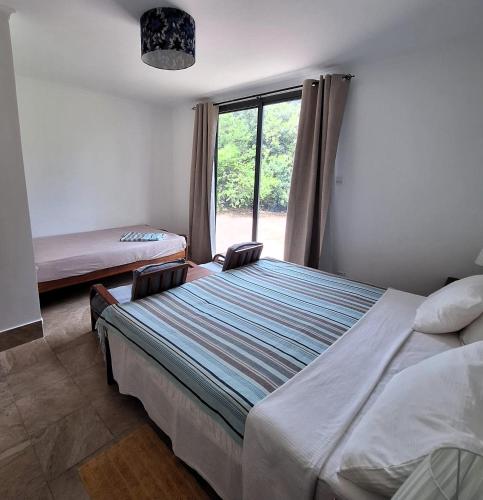 a bedroom with two beds and a window at Kipepeo Beach and Village in Dar es Salaam