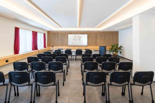 a room with rows of chairs and a screen at Hotel Sonne St. Moritz 3* Superior in St. Moritz