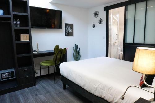 a bedroom with a bed and a desk and a chair at Villa Pruly Hotel Cannes Centre in Cannes