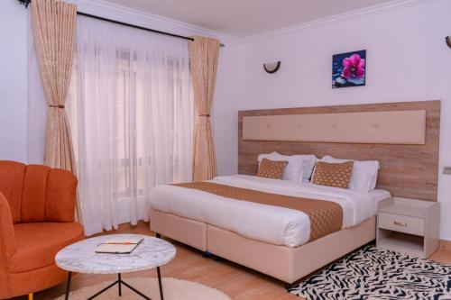 ein Schlafzimmer mit einem großen Bett und einem Stuhl in der Unterkunft Midview in Nakuru