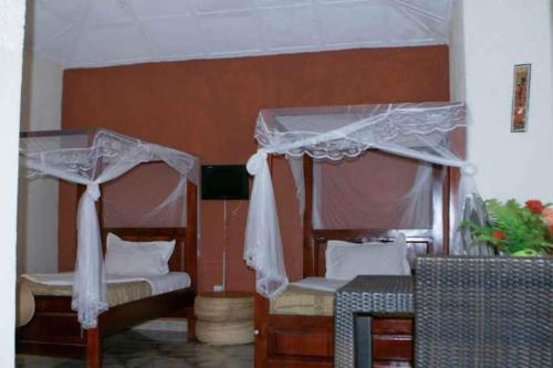 a bedroom with two beds with mosquito nets on them at Gorilla African Guest House in Entebbe