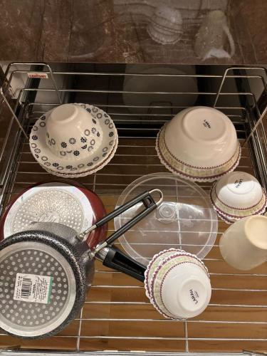 a strainer in a glass rack with some dishes at Anmolairbnb in Greater Noida