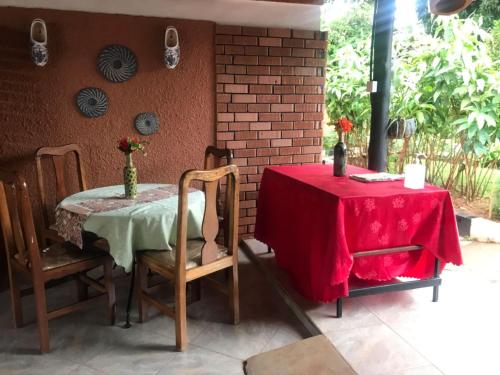 a table and chairs with a red table cloth on it at Gorilla African Guest House in Entebbe