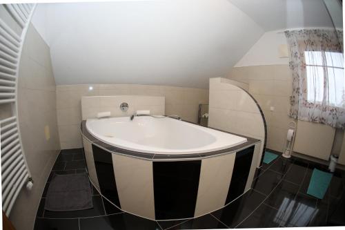 a bathroom with a black and white bath tub at Zum Stroama in Wies