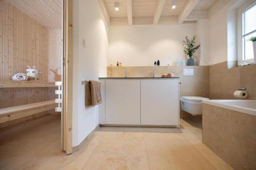 ein Badezimmer mit Badewanne, Toilette und Waschbecken in der Unterkunft Villa am See für bis zu 6 Personen mit Kaminofen, Badewanne und Sauna - Haustiere herzlich willkommen, direkt am Wasser gelegen in Nordhorn