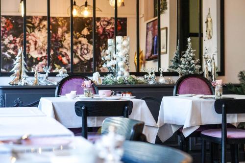 a restaurant with tables and chairs with white tablecloths at Villa Pruly Hotel Cannes Centre in Cannes
