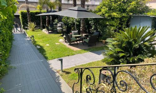 a patio with a table and an umbrella and chairs at Villa Pruly Hotel Cannes Centre in Cannes