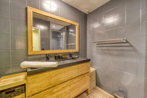 a bathroom with a sink and a mirror at R'Apparts Le Central Park in Grenoble