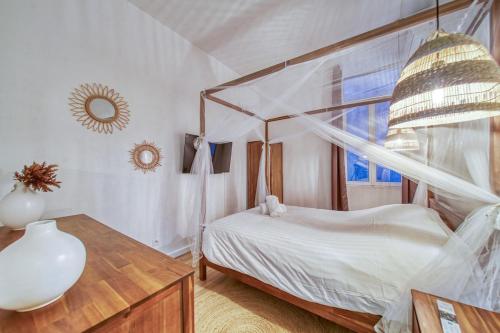 a bedroom with a canopy bed and a wooden table at R'Apparts Le Central Park in Grenoble