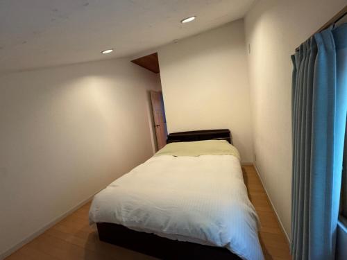 a small bedroom with a bed and a window at Cabin G Lake Saiko 1min, MtFuji View, BBQ, Hammock, fire pit in Narusawa