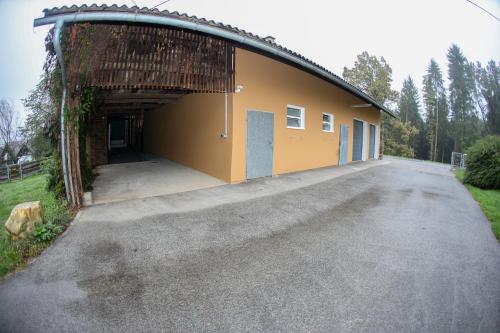 a large building with a garage with a driveway at Zum Stroama in Wies