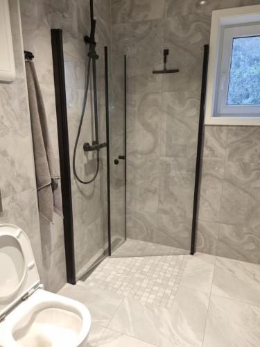 a bathroom with a shower and a toilet at Modern apartment in Drammen