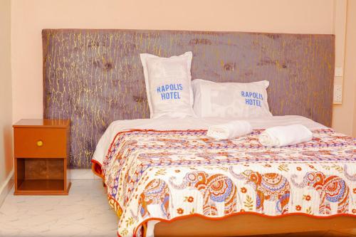 a bedroom with a bed with two pillows on it at Rapolis Hotel Keroka in Keroka