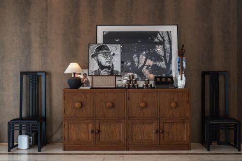 a wooden dresser with a lamp and a picture on it at Dishui Shanfang Garden Hotel in Shanghai