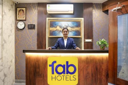 a woman is standing behind a reception desk at FabHotel Gateway in Mumbai