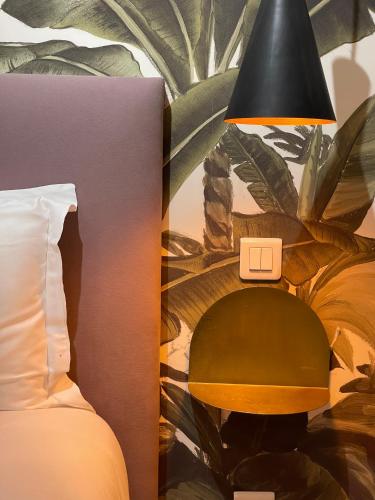 a lamp sitting next to a bed with a plant at Villa Pruly Hotel Cannes Centre in Cannes
