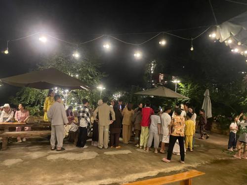 a group of people standing around a market at night at Huha's Farmstay Đà Lạt in Lạc Dương